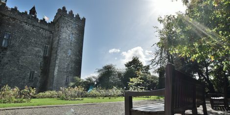 Bunratty Castle's battlemented keep seen across the forecourt, with the flag flying