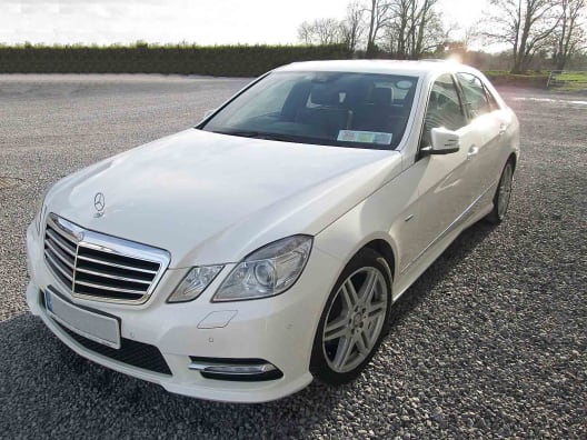A white two seater Mercedes E Class luxury saloon car