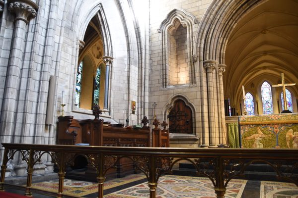 The Gothic stone archways and patterned floor tiles