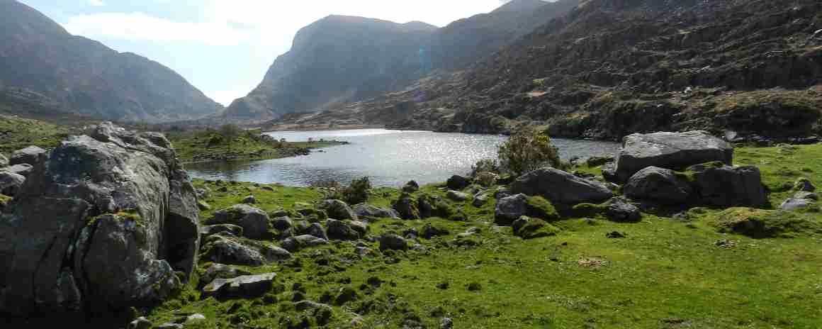 The Gap of Dunloe with an old bridge and walkers. 