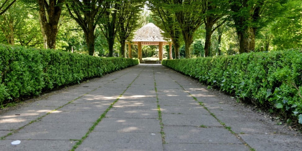 The manicured grounds of Adare Town Park with its thatched gazebo