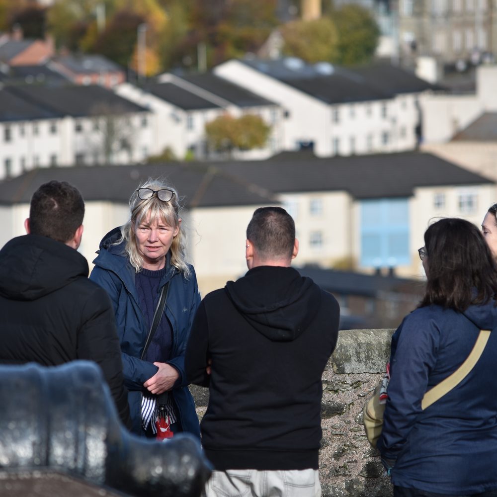 Guests chatting together on the historic city walls of Derry