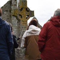 A tour group at the ancient high crosses of Clonmacnoise